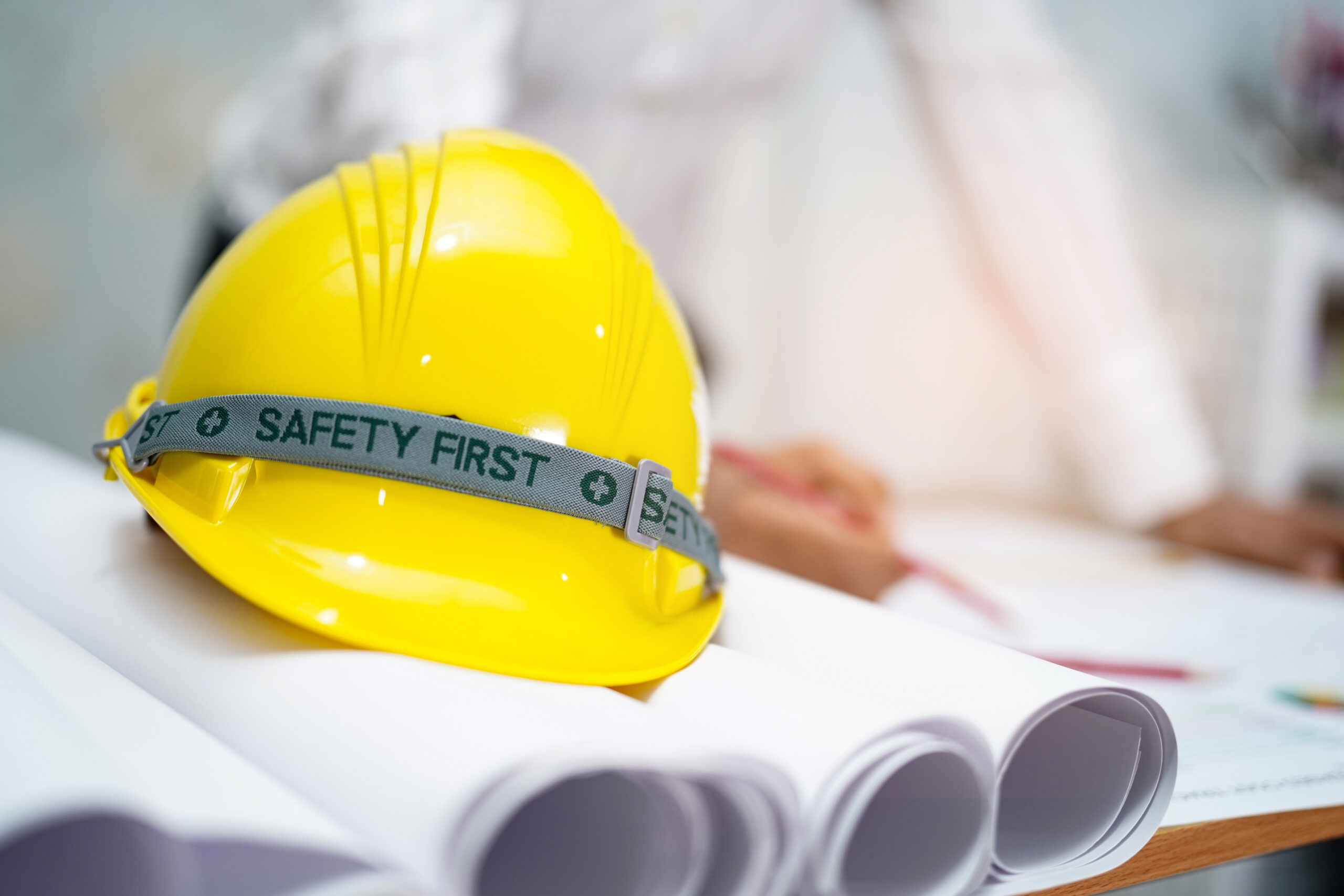 Yellow helmet with blueprint : engineer safety concept.